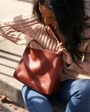 woman using Handmade leather shoulder bag with short handle in persimmon